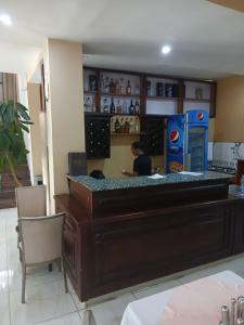 una persona sentada en un bar en un restaurante en Kitsel Hotel, en Bahir Dar