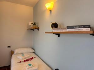 a room with a bed and a cat sitting on a shelf at Grigna Roberta s Lodge - Wi-Fi Gratuito in Civenna
