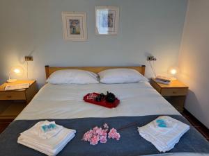 a bedroom with a bed with two tables and two towels at Grigna Roberta s Lodge - Wi-Fi Gratuito in Civenna