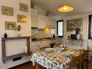 a kitchen with a table with chairs and a table cloth at Grigna Roberta s Lodge - Wi-Fi Gratuito in Civenna