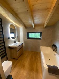 une salle de bain avec une baignoire blanche et un lavabo dans l'établissement Apartmány La Torretta, à Harrachov