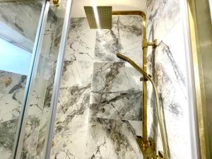 a shower in a bathroom with a marble wall at The Townhouse Collection 2BR Close To City Centre in Cardiff +39 photos