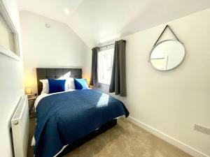 a bedroom with a blue bed and a mirror at The Townhouse Collection 2BR Close To City Centre in Cardiff