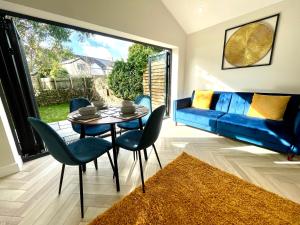 a living room with a blue couch and a table and chairs at The Townhouse Collection 2BR Close To City Centre in Cardiff