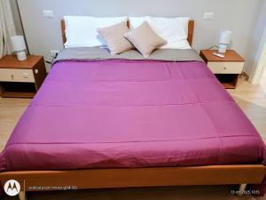 a bed with a purple blanket on top of it at la piccola corte del borgo in Milan +8 photos