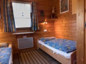 two beds in a room with a window at Ferienhaus Nr 5, Typ A, Feriendorf Jägerpark, Bayerischer Wald in Prackenbach