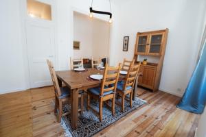 a dining room with a wooden table and chairs at Alfarrobeira House in Cascais