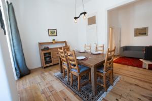 a dining room with a wooden table and chairs at Alfarrobeira House in Cascais