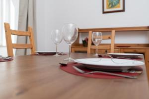 a table with wine glasses and a plate on it at Alfarrobeira House in Cascais