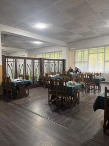 a restaurant with tables and chairs and people sitting at tables at Моршинский in Dobrovelychkivka