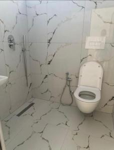 une salle de bain blanche avec toilettes et lavabo dans l'établissement Aura Apartaments 3, à Tirane