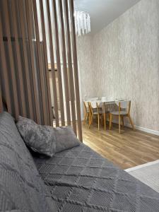 a bedroom with a bed and a table with chairs at Prestige Ap in Ustʼ-Kamenogorsk