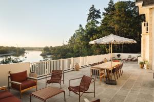 a patio with chairs and a table with an umbrella at Maison Roz Superbe maison face à l'Aven in Riec-sur-Bélon