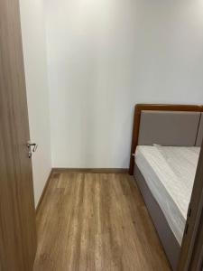 a small bedroom with a bed and a wooden floor at H-Vista Suites - The Wisteria  +1 photo