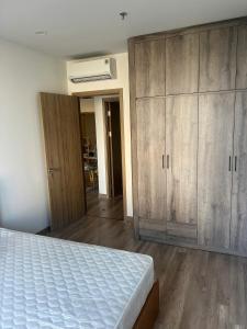 a bedroom with a bed and a large wooden cabinet at H-Vista Suites - The Wisteria 