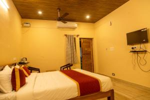 蓬蒂切里Le Pon Villa的一间卧室，里面有一张床和一台平板电视