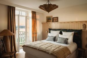 a bedroom with a large bed with a large window at Maison Roz Superbe maison face à l'Aven in Riec-sur-Bélon