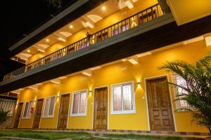 蓬蒂切里Le Pon Villa的夜晚的一栋黄色房子，有窗户和阳台。