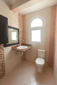 a bathroom with a toilet and a sink and a window at Sea Breeze Apartment Sharm el-Sheikh in Sharm El Sheikh +4 photos