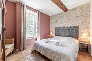a bedroom with a large bed in a room with red walls at Le Lieutenant in Bonnieux