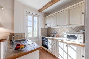 a kitchen with white cabinets and a bowl of fruit on the counter at Le Lieutenant in Bonnieux