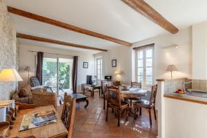 a kitchen and living room with a table and chairs at Le Lieutenant in Bonnieux
