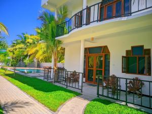 a house with a balcony and a swimming pool at Blue skies guest house and restaurant in Tangalle