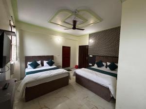 una camera da letto con due letti e un ventilatore a soffitto di Hotel AYODHYA HERITAGE a Ayodhya Altre 12 foto