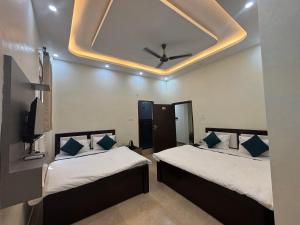 2 letti in una camera con soffitto di Hotel AYODHYA HERITAGE a Ayodhya