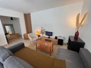 a living room with a couch and a table at Chambre Cosy proche Part Dieu in Villeurbanne