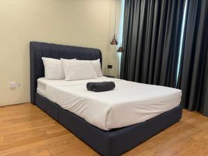a bed with a black headboard and white pillows at Vortex klcc lotus in Kuala Lumpur