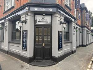 a small building with a sign above a door at Sarah Hotel in Harwich