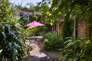 a table with a pink umbrella in a garden at York Pavilion Hotel, BW Signature Collection in York
