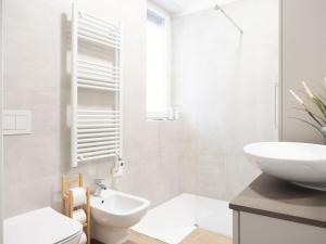 une salle de bain blanche avec un lavabo et des toilettes dans l'établissement suite boutique viale assunta 90, à Cernusco sul Naviglio