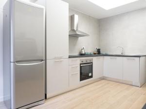 une cuisine avec des armoires blanches et un réfrigérateur en acier inoxydable dans l'établissement suite boutique viale assunta 90, à Cernusco sul Naviglio