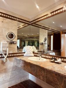 a bathroom with a sink and a large mirror at Tunis Grand Hotel in Tunis