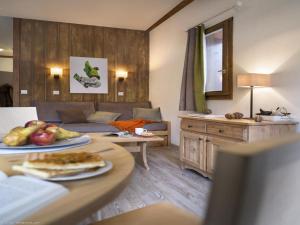 a living room with a couch and a table at Charmant studio centre Val d'Isère - Balcon vue montagne - in Val dʼIsère