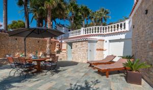 a patio with a table and chairs and an umbrella at Vista Hermosa in Moraira