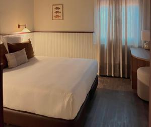 a bedroom with a large white bed in a hotel room at Hotel Medium Montecarlo in Llafranc