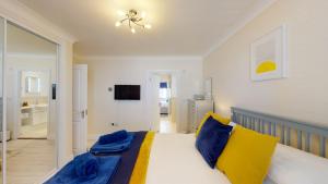 Un dormitorio con una cama con almohadas azules y amarillas. en Finelia House, en Topsham