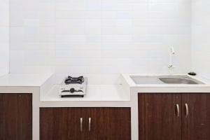 a kitchen with a sink and a counter top at RedDoorz Syariah near Tanjung Pinang City Center in Tanjung Pinang  +3 photos