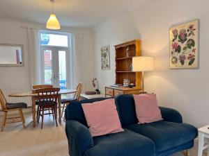 a living room with a blue couch and a table at Thimble Cottage in Sidmouth
