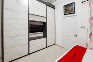 a kitchen with white cabinets and a red bench at RedDoorz Syariah near Tanjung Pinang City Center in Tanjung Pinang 