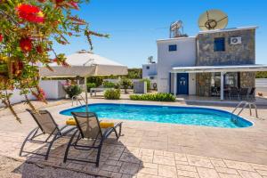 a villa with a swimming pool and a house at Villa Galazio by Villa Plus in Argaka
