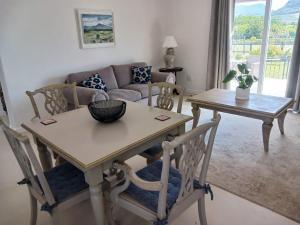 a living room with a table and chairs and a couch at La Jolie Dauphine Guest House in Franschhoek