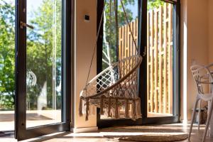 a porch with a swinging bench in front of a door at Na.Zadkach in Klon