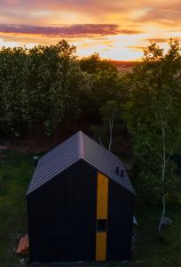 un capannone nero e giallo con un tramonto sullo sfondo di Na.Zadkach a Klon