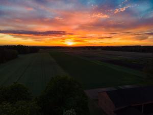 a sunset over a field with the sun setting at Na.Zadkach in Klon