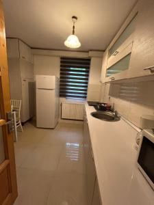 a kitchen with a sink and a white refrigerator at Aparthotel Brasov Neptun in Braşov