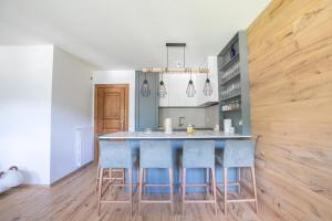 a kitchen with a island with blue bar stools at Ruoibes 17 in San Vito di Cadore